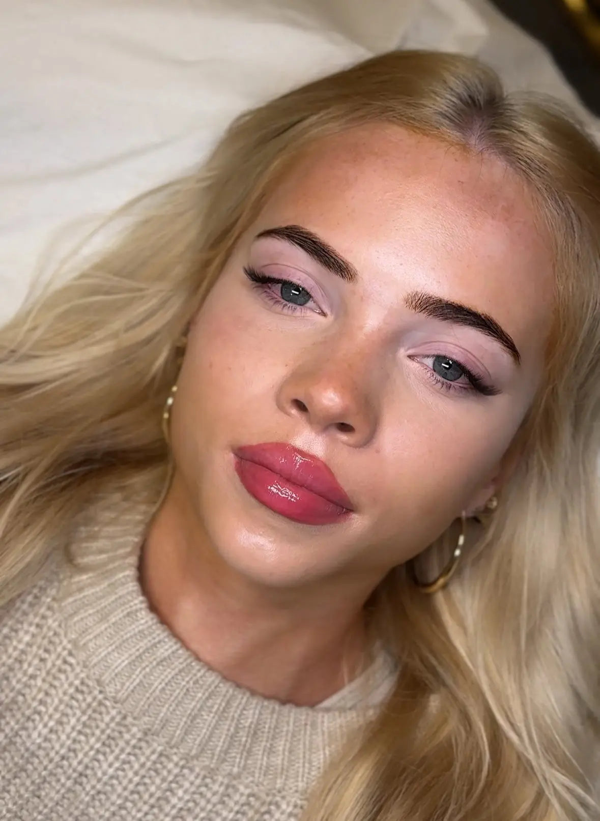 Close-up of a blonde client wearing the Fox Eye lash extension style, showcasing lifted outer corners and defined lash direction using L curl.
