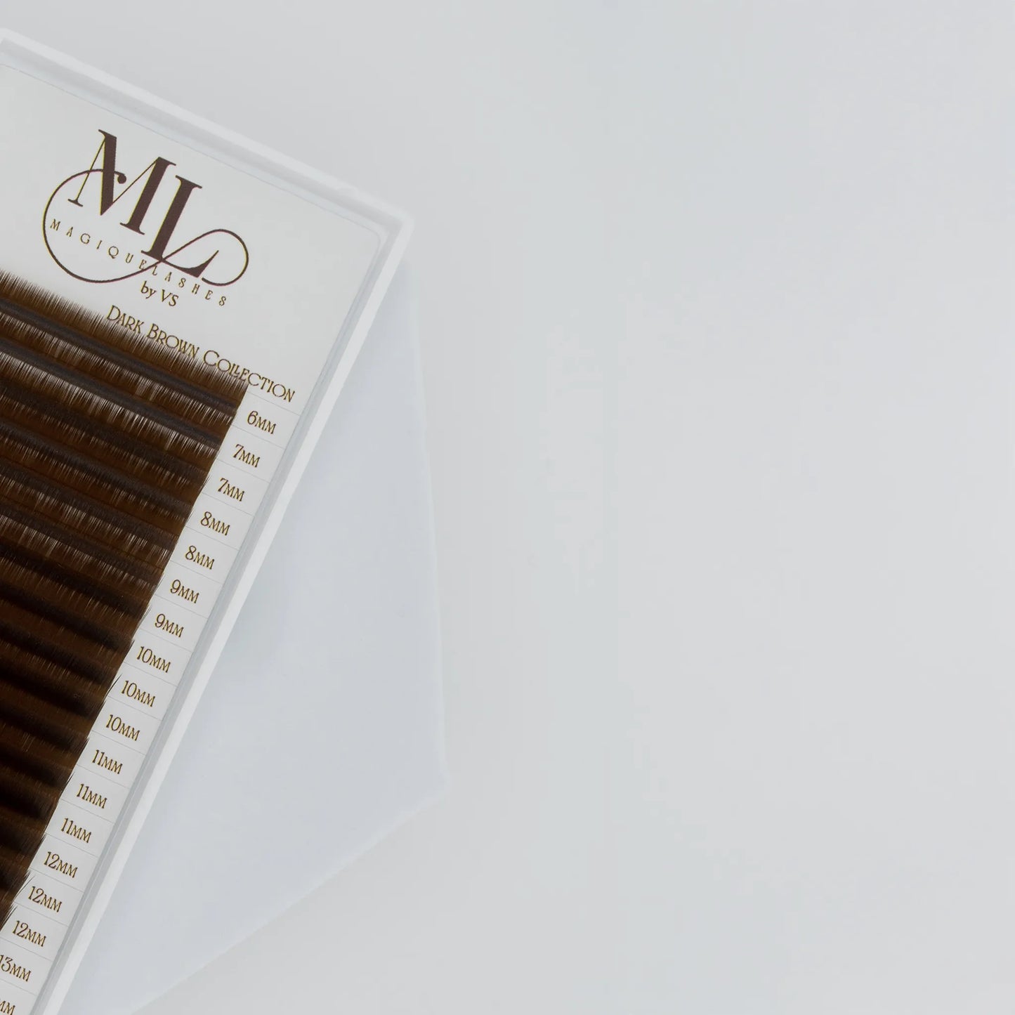 Close-up of MAGIQUE Pecan brown eyelash extensions showing mixed lengths and soft warm lash fibres.