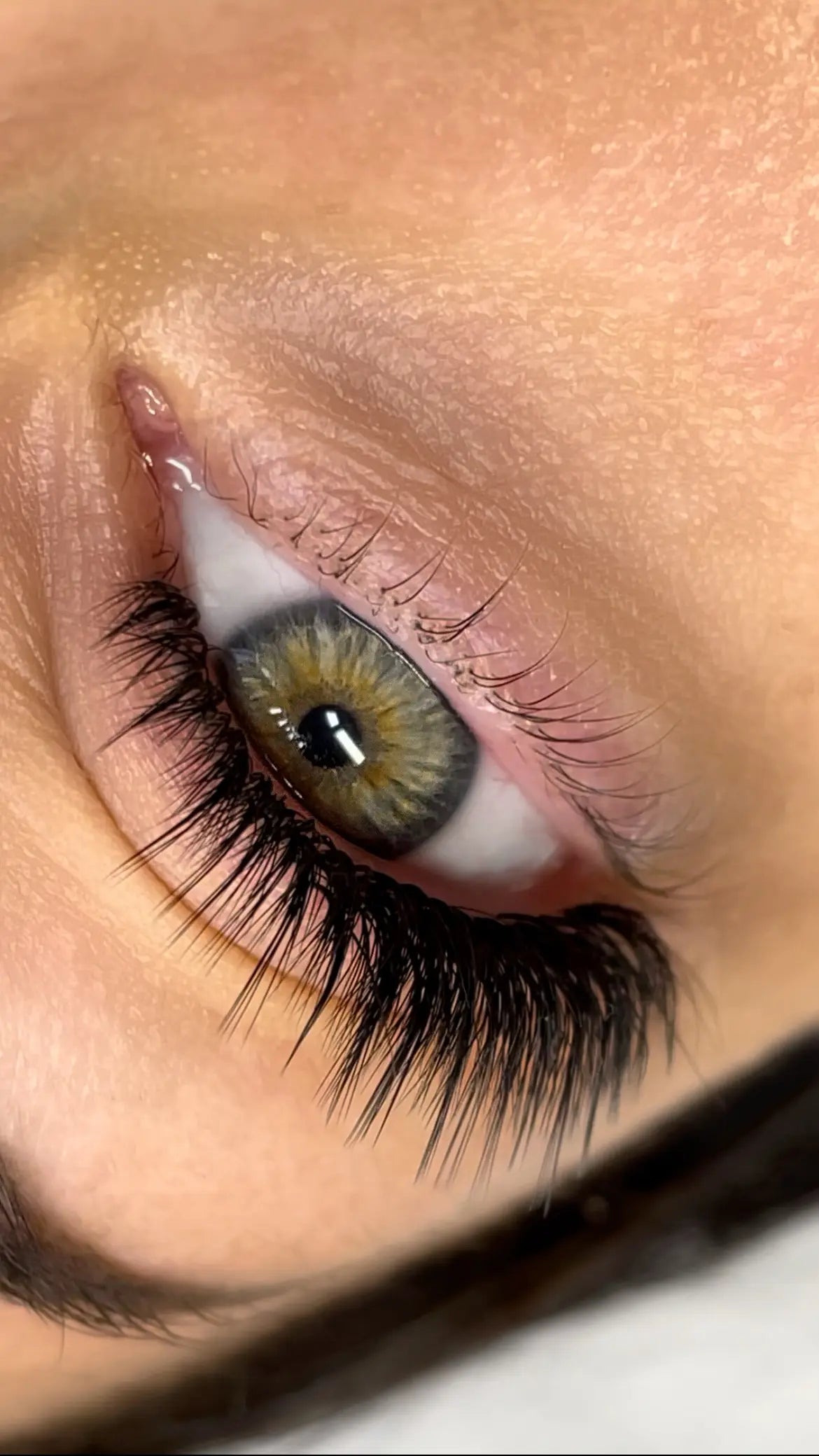 Close-up of a wispy eyelash extension set styled in the Kim K effect, showing defined spikes and seamless lash line attachment.