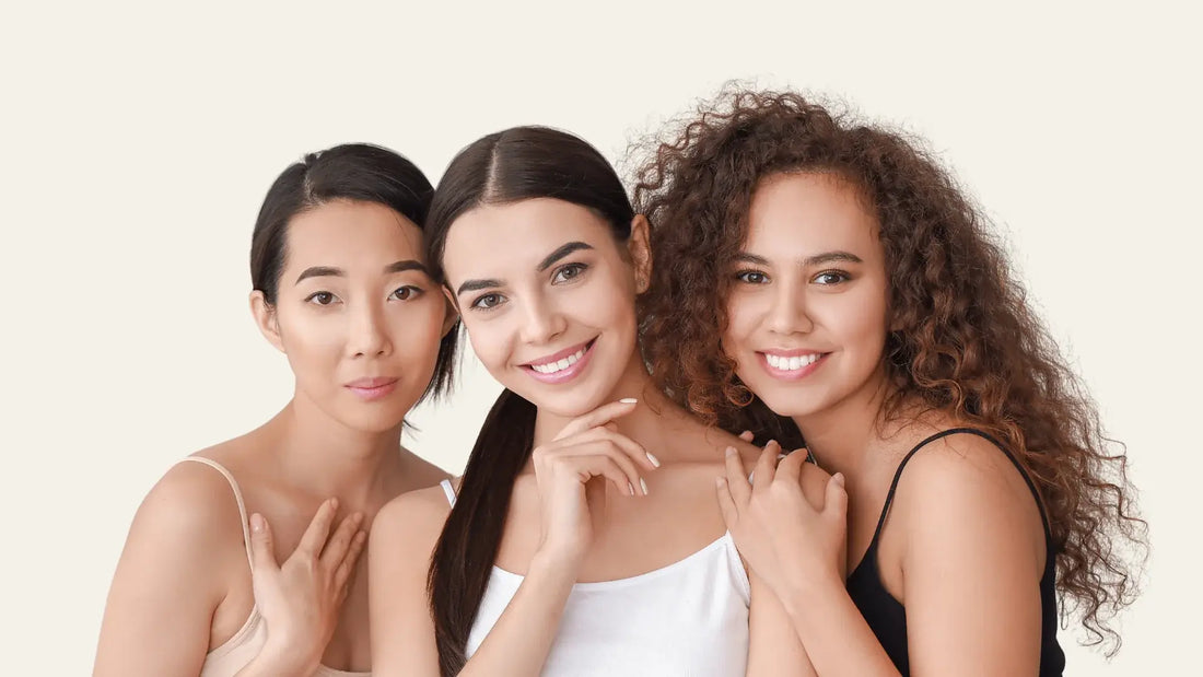 Three diverse women smiling with lash extensions, representing loyal lash clients