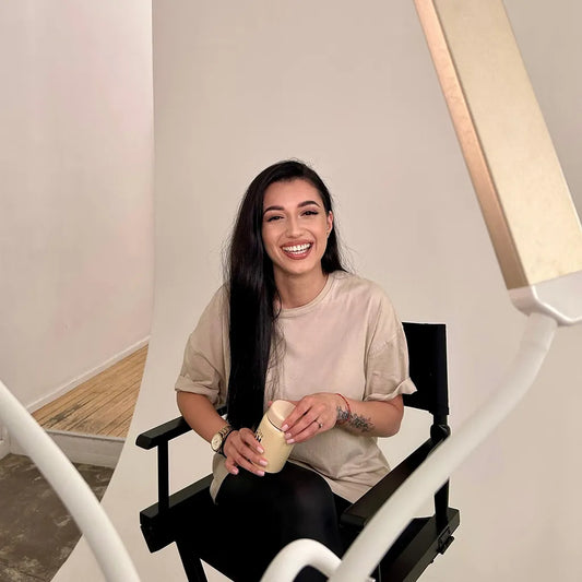 Lash artist smiling on set during content shoot, representing confidence and personal branding in the lash business journey