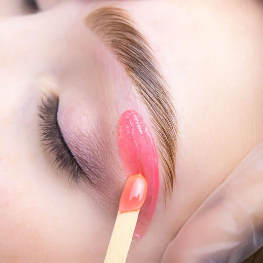 Brow waxing treatment in progress – precise shaping without tint for a clean, natural finish