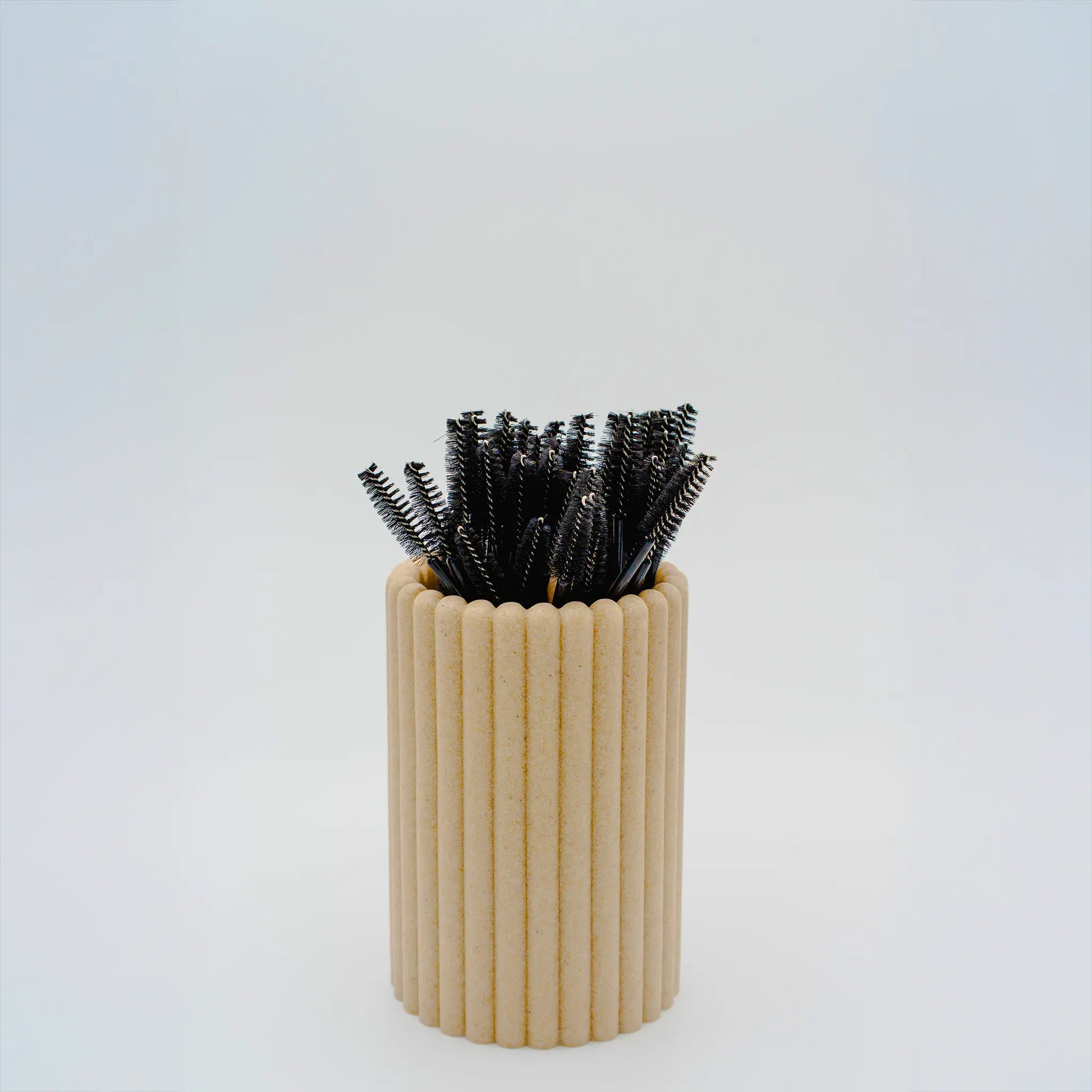 Disposable mascara wands for eyelash extensions stored in a beige holder, 50 pack ideal for lash maintenance and client aftercare, The Lash Box Shop.