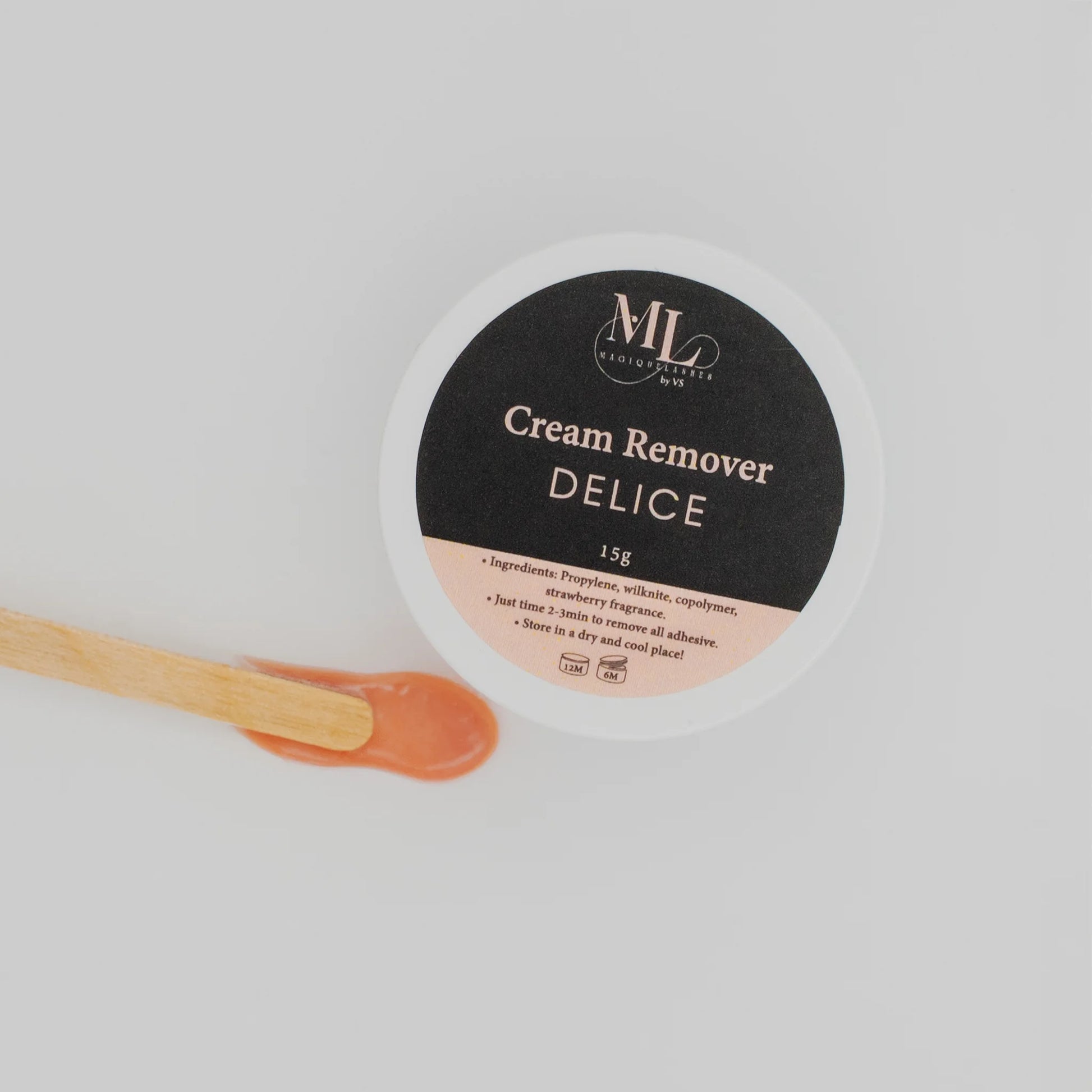 Close-up of Delice cream remover texture with wooden spatula for eyelash extension removal.