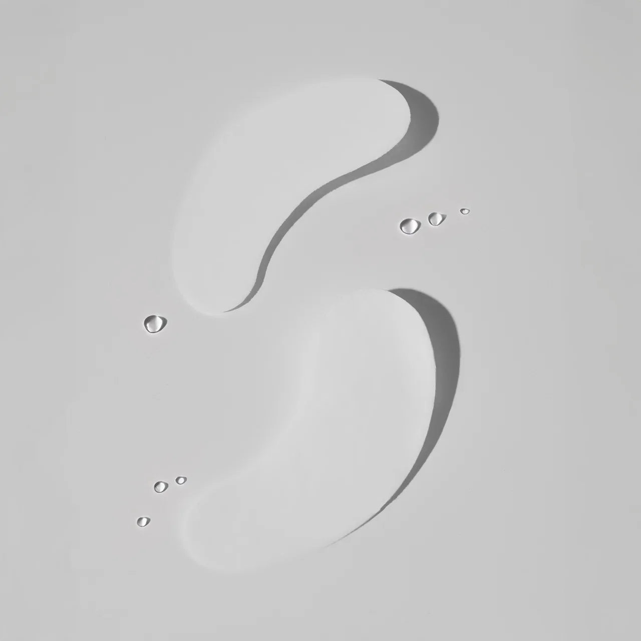 Flat lay of hydrogel under eye patches for eyelash extensions with water drops.