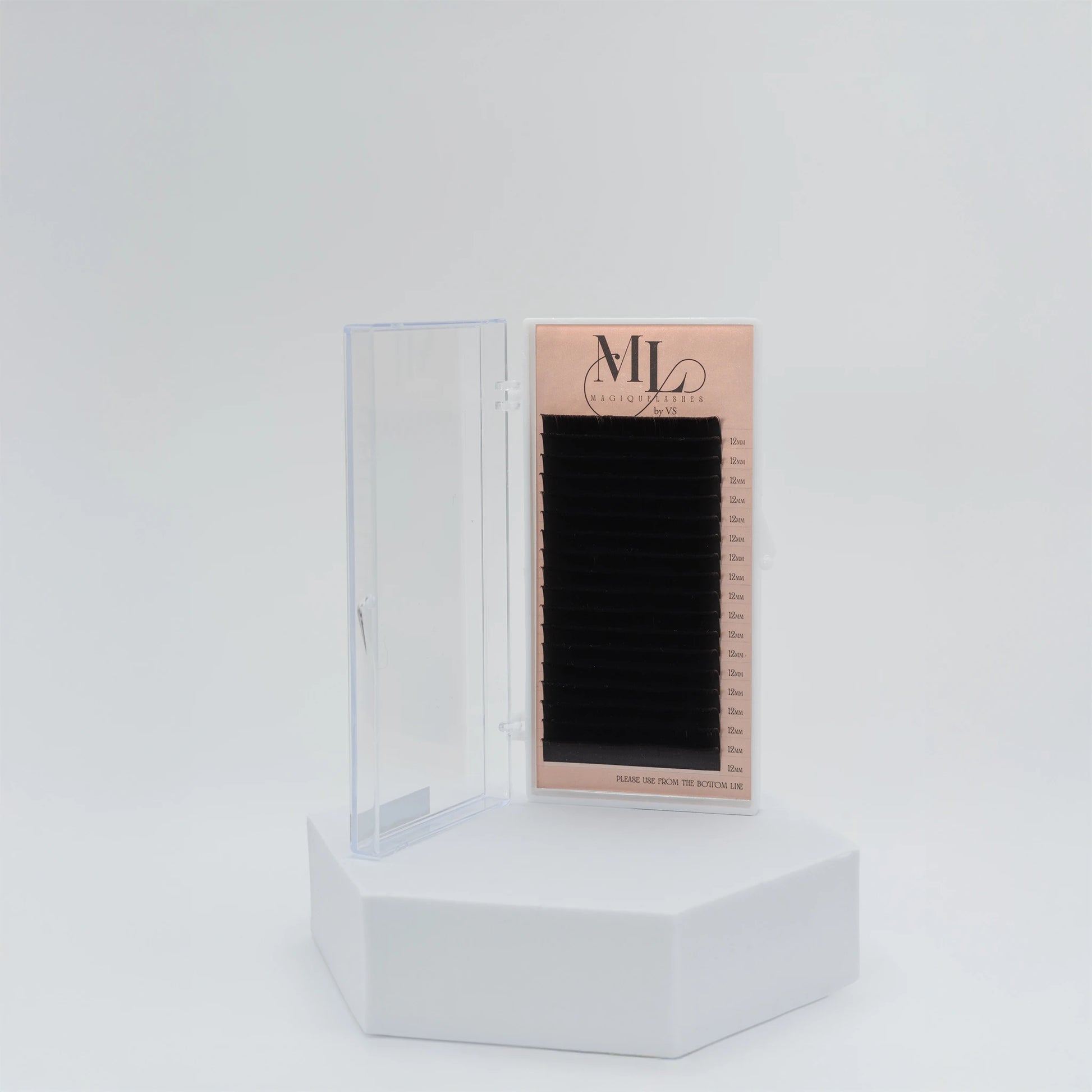 MAGIQUE black eyelash extensions tray in closed plastic case, displayed on white pedestal.