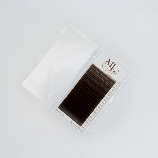 Top view of MAGIQUE Coffee brown eyelash extensions tray showing lash strip lengths and soft mid-brown fibres.