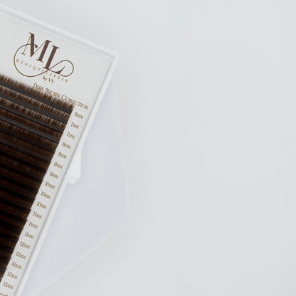 Close-up of MAGIQUE Coffee brown lash tray with visible lash lengths from 6mm to 15mm and soft faux mink finish.
