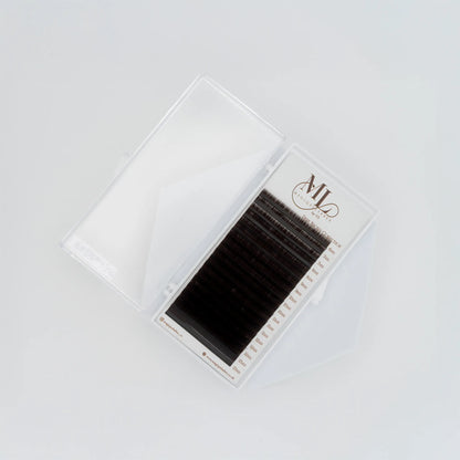Top view of MAGIQUE Espresso brown lash tray inside open clear case, showing mixed lengths and lash strip labels.