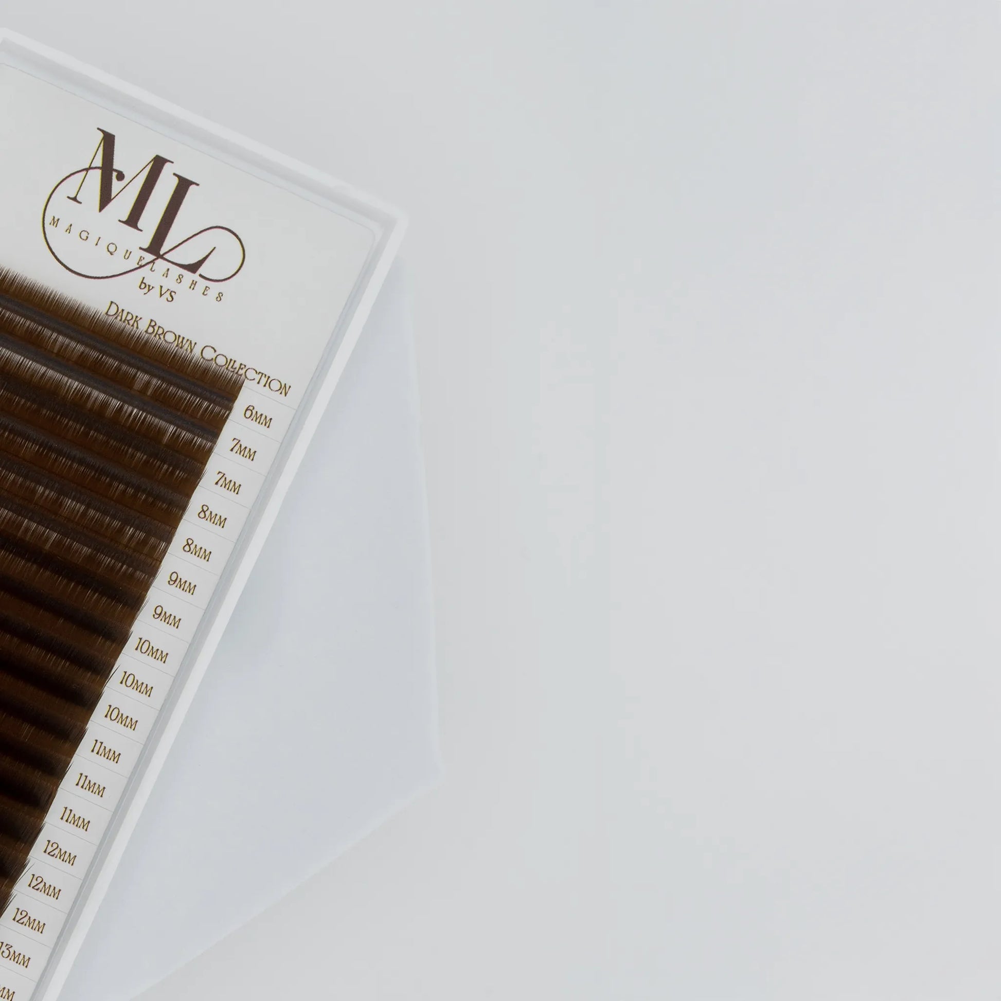 Close-up of MAGIQUE Pecan brown eyelash extensions showing mixed lengths and soft warm lash fibres.
