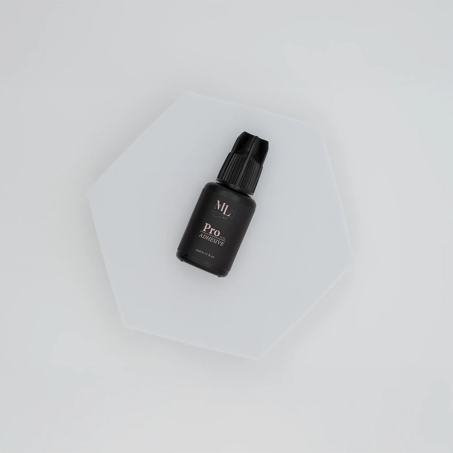 Pro Lash Adhesive for eyelash extensions, fast-drying lash glue displayed on a white hexagon base, ideal for professional lash artists, The Lash Box Shop.