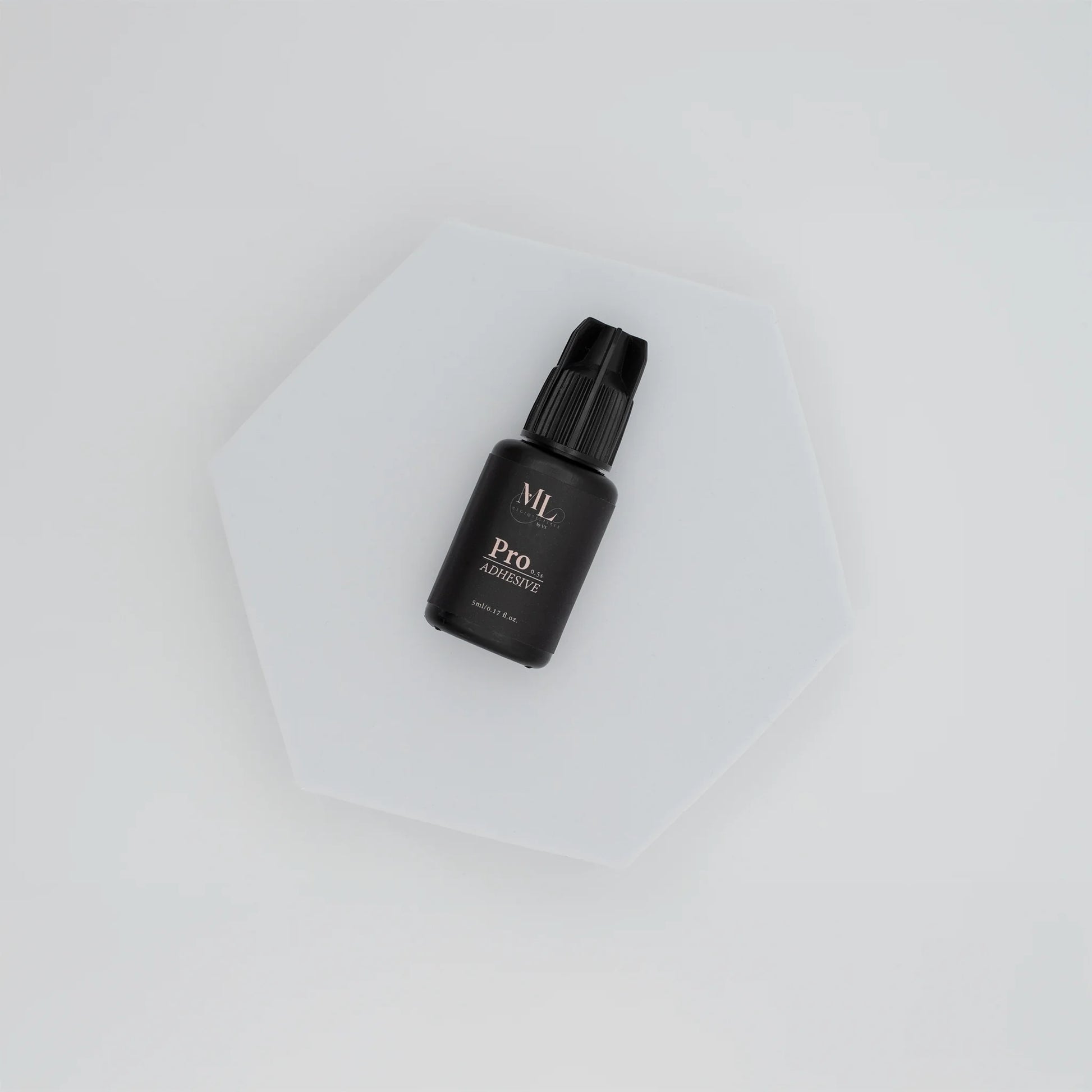 Pro Lash Adhesive for eyelash extensions, fast-drying lash glue displayed on a white hexagon base, ideal for professional lash artists, The Lash Box Shop.