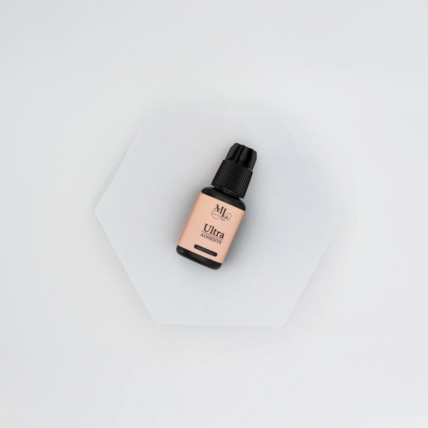 Ultra Lash Adhesive for eyelash extensions, fast-drying lash glue displayed flat on a white hexagon base, ideal for beginner to intermediate lash artists, The Lash Box Shop.
